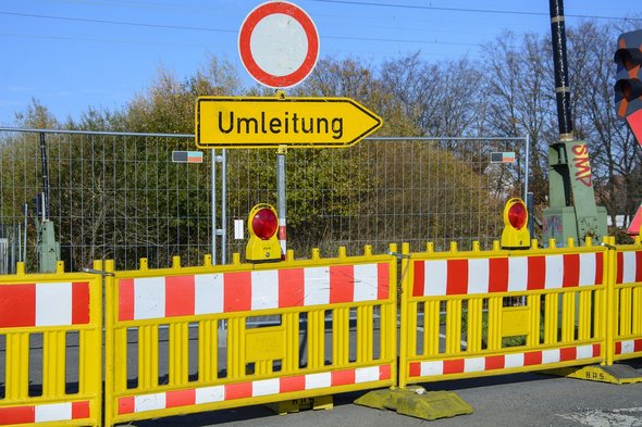 Ein gelber Baustellenzaun mit einem Umleitungsschild.
